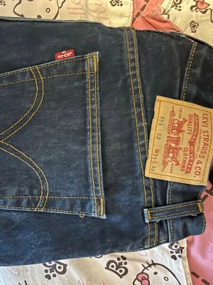 Levi's 517 blå jeans W31 L32 - Säljer ett par klassiska Levi's 517 jeans i mörkblå denim. Byxorna har låg midja, raka ben och den ikoniska röda Levi's-lappen på bakfickan. Tydliga kontrastsömmar och slitstark bomull gör dem till ett måste i garderoben. Perfekta till sneakers eller boots. Midja- ish 35, innerben ish 83cm