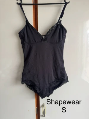 Fin svart spetsig. Storlek S - Vet ej om de kallas shapewear när den är som en body men vet ej vad det heter mer korrekt .  Passar på att göra om mina annonser så du kan få gratis frakt (gäller i 7dagar) står det ej gratis frakt så har tiden passerat. 🌹❤️ alla mina kläder är i fint/okej skick utan större defekter om inget annat står . Allt är använt så vanligt slitage kan förekomma 