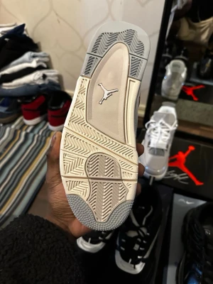 Nike Air Jordan 4 Retro Frozen Moments - Nike Air Jordan 4 Retro i vitt med silverdetaljer. Skon har meshpaneler, mocka och skinn på ovandelen samt metalliska inslag vid snörningen. Sulan är vit med grå inslag och har den klassiska Air-dämpningen. Perfekt för dig som vill sticka ut med en clean och modern sneaker.