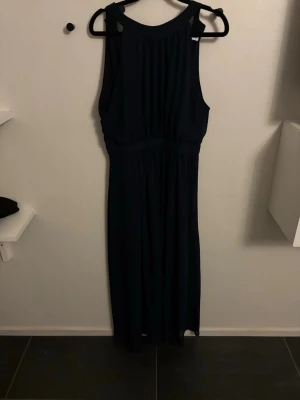 Mörkblå långklänning från Vila - Säljer en elegant mörkblå långklänning från Vila i storlek 38. Klänningen har ärmlös design💕💕