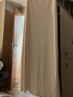 Lång beige kjol  - Säljer en lång, beige kjol i mjukt material. Kjolen har en enkel och stilren design utan mönster eller detaljer, vilket gör den lätt att matcha med olika toppar. Perfekt för dig som gillar minimalistisk stil. Från Gina Tricot, ingen lapp eftersom den syntes lite igen för att den var svart i stl XS/S ganska töjbar.