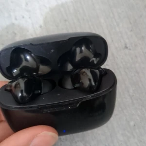 Juice AirPhon Play-TES Trådlösa Hörlurar - Juice AirPhon Play-TES trådlösa hörlurar med laddningsetui. Svart färg, synligt bruksslitage på etuiet men fungerar. Perfekt för musik och samtal på språng. Laddningsetui med LED-indikator, 3.7V/200mAh batteri. Levereras utan extra tillbehör.