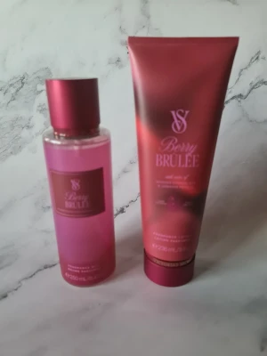 Berry Brûlée mist & lotion set victorias secret - Berry Brûlée från Victoria's Secret är ett set med fragrance mist (250 ml) och lotion (236 ml). Flaskorna har en snygg röd design och beskrivs med 'Juicy red fruit dances around creamy confections'. Perfekt för dig som vill ha en söt och fräsch känsla hela dagen. Helt nytt och oanvänt 