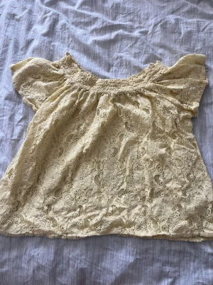 Spetsblus Bik Bok - Säljer den här söta gula toppen med blomspets från BikBok. Storlek M sitter som S. Knappt använd💛