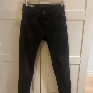Replay Grover svarta jeans - Svarta jeans från Replay, modell Grover, med straight fit och klassisk femficksdesign. Jeansen har normal passform och är tillverkade i ett slitstarkt jeansmaterial. Snygga svarta detaljer och diskret Replay-logga vid fickan. Perfekt för en clean och stilren look.