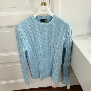 Ljusblå Kabelstickad Ralph Lauren Tröja - Väldigt sällsynt modell, säljs för ca 5000 kr i andrahand just nu! Inköpt i Ralph Lauren butik på Honolulu, Hawaii Fint skick! Storlek: S