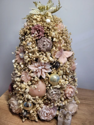 Julgran ljusblommor - Bilderna visar en dekorativ julgran gjord av ljusblommor, torkade växter och julkulor i mjuka pastellfärger. Produkten är handgjord och passar perfekt som bordsdekoration under julen. Den är ca 35 cm hög och 17 cm bred.