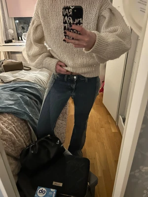 Blå bootcut jeans med kontrastpaneler - Snygga blå jeans med bootcut passform och coola kontrastpaneler längs sidorna. Jeansen har klassisk femficksdesign, knapp och dragkedja framtill samt markerade sömmar. Perfekta för dig som vill sticka ut med en unik look. Från weekday 
