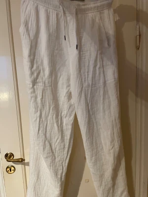 Vita linnebyxor med snörning - Snygga vita linnebyxor med avslappnad passform och elastisk midja med snörning. Byxorna har en lätt och luftig känsla. Köpt på New Yorker och använt några gånger men den är i mycket bra skick. Säljs i befintlig skick. 