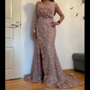 Festklänning  - Endast använd en kväll Enarmad klänning med pärlor och fint släp Puderrosa i färgen Tvättad och i fint skick. Storlek 38/ liten 40