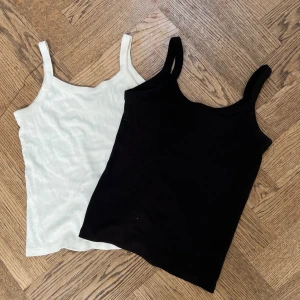 2-pack ribbade linnen från H&M svart/vit - Två helt oanvända ribbade linnen från H&M i storlek 158/164. Ett är helsvart och det andra är helvitt, båda med smala axelband och rundad hals. 