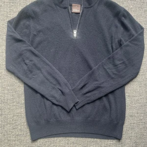 Mörkblå half zip tröja Oscar Jacobson - Klassisk mörkblå långärmad tröja från Oscar Jacobson med halv dragkedja och hög krage. Tillverkad i mjuk ull, perfekt för lager-på-lager. Snygg ribbad mudd vid ärmslut och nederkant. Made in Italy – stilren och tidlös design. Väldigt fint skick🤩Hör av er vid frågor och funderingar👏 svarar ofta snabbt🙌kom gärna med prisförslag så kan vi säkert lösa något som funkar för båda😄