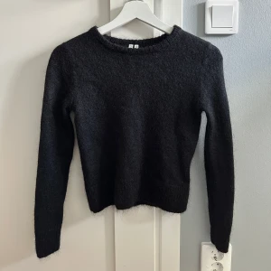 Svart stickad tröja från Arket - Mysig svart stickad tröja från Arket i bland annat ull och mohair. Materialet består av 41% polyamid, 34% mohair och 25% ull. Säljer då den är för liten. 