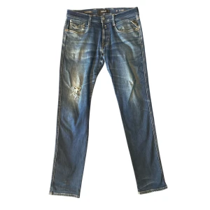 Replay jeans anbass slim fit - Replay jeans, storlek W33 L32, modell: anbass/slim fit, bra skick men har lite distress och en stor slitning på knät vilket ger jeansen karaktär.