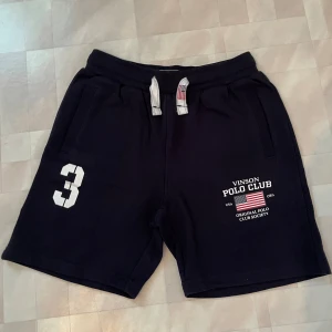 Svarta shorts Vinson Polo Club - Svarta shorts från Vinson Polo Club med vit tryckt siffra 3 och logga framtill. De har snörning i midjan med vita snören och två sidofickor. 🔴OBS STORLEK BARN 12!🔴