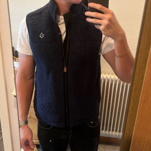 Mörkblå fleeceväst från Morris - Säljer en mörkblå fleeceväst från Morris med hög krage och dragkedja framtill. Pris kan diskuteras vid snabb affär.