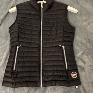 Svart dunväst från Colmar - Snygg svart dunväst från Colmar som är perfekt under hösten, våren  och kalla sommar dagar. Använd fåtal gånger och den ser ut som ny. Pris kan diskuteras.