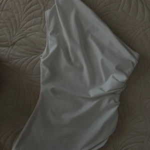 Vit asymmetrisk one shoulder  topp - Snygg vit  topp med enaxlad design som ger en modern och stilren look. Enkel och clean utan mönster eller extra detaljer.