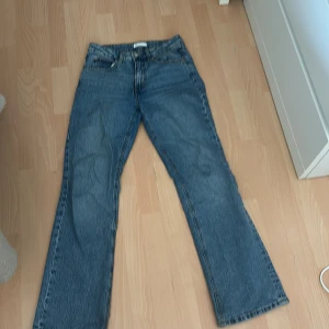 Blåa bootcut jeans från Gina Tricot - Säljer ett par klassiska blåa jeans från Gina Tricot, modell 'perfect jeans'. De har bootcut-ben, normal passform och är tillverkade i jeansmaterial. Perfekta för dig som gillar en tidlös look med lite utsvängda ben.