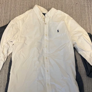 Vit Polo Ralph Lauren skjorta L - Vit polo skjorta i storlek L, aldrig andvänt den, säljer för att den är för stor på mig med längden.
