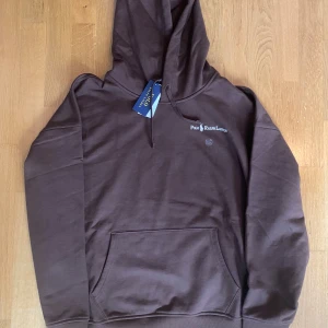 Brun hoodie från Polo Ralph Lauren - Snygg brun hoodie från Polo Ralph Lauren med broderad logga på bröstet. Klassisk känguruficka framtill, huva med dragsko och långa ärmar. Köptes för 2000kr. Helt ny med alla tags kvar. Säljs då den inte passade. 100% äkta, skriv vid frågor! 🤩Priset är diskutabelt 👍