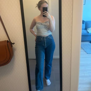Raka jeans  - Super snygga jeans i jätte fint skick som är raka och har en hög midja, som jag tyvärr har växt ur i. Är mjukt material. Har flera knappar i mitten vid gylfen där man knäpper ihop. Storlek 32. Jag är 158 cm lång och passar bra till längden. Nypris: 279 kr
