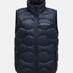 Svart dunväst från Peak Performance - Snygg svart dunväst från Peak Performance med vågformat quiltat mönster och hög krage. Västen har dragkedja framtill och diskret logga broderad på bröstet. Ge gärna prisförslag.(Skriv för egna bilder och frågor💕)