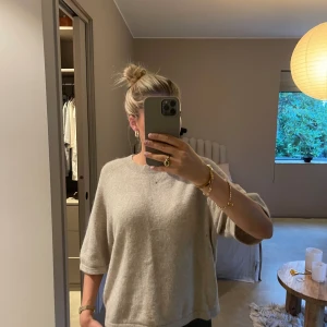 Beige stickad tröja & Other Stories - Supermjuk och trendig beige stickad tröja från & Other Stories med rund halsringning och trekvarts armar.