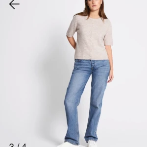 Beige stickad blus med pärlknappar - Superfin beige stickad blus med korta ärmar och rund hals. Framtill sitter pärlknappar som ger en söt touch. Mjuk och skön kvalitet, perfekt till jeans eller kjol. Enkel och stilren design som är lätt att matcha. Har inte använt den efter som den blev inte som jag trodde den kommer med klädetikett
