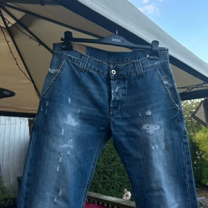 Dondup jeans - Säljer ett par dondup jeans som inte kommit till användning över huvudtaget. Dessa jeansen är ganska hårda i sin form, drar mer åt det tidlösa Levi’s 501 i känslan. De har ett par snygga slitningar lite här och var på byxorna. Annars sitter de lite mer straight/relaxed. Storleken sitter i 32 men går nog bra åt båda hållen.