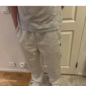 Grå mjukisbyxor från Polo Ralph Lauren - Snygga ljusgrå mjukisbyxor från Polo Ralph Lauren med klassisk broderad logga på benet. Byxorna har resår i midjan och raka ben, tillverkade i mjuk bomullsmix som är riktigt skön att ha på sig. Perfekta för chill eller streetwear.