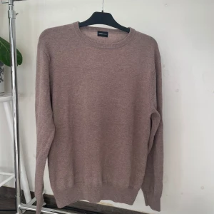Beige merinoulltröja från Swedish Fashion - Supermjuk beige stickad tröja från Swedish Fashion i storlek L men sitter som en M. Tillverkad i 90% merinoull och 10% kashmir för extra lyxig känsla. Klassisk rund halsringning och långa ärmar, perfekt för lager-på-lager under kyliga dagar.