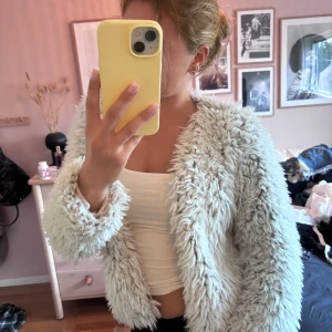 Vit pälsjacka från H&M - Säljer en fluffig och supermjuk vit pälsjacka från H&M. Jackan har lång ärm och är fodrad på insidan för extra komfort. Perfekt för dig som vill sticka ut och hålla dig varm med stil. Passar dig som gillar trendiga och mysiga plagg. Passar som xs 