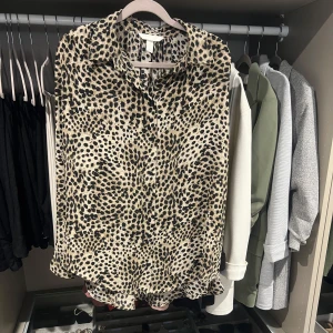 Leopardmönstrad blus - Snygg långärmad blus i leopardmönster i beige, svart och bruna toner. Ledig passform i strl S men passar även som M