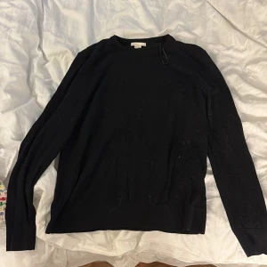 Svart merinoullströja i medium - En stilren svart tröja i merinoull, perfekt för dig som gillar en enkel och klassisk look. Tröjan har rund halsringning och långa ärmar. Passar lika bra till jeans som till kostymbyxor. Supermjuk och skön mot huden.