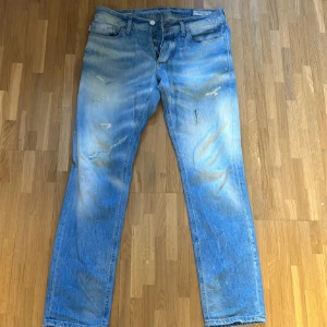 Ljusblå slitna jeans från Jack & Jones - Ljusblå jeans från Jack & Jones med slitna detaljer och snyggt tvättad look. Klassisk femficksmodell med knappgylf och tydliga slitningar på både lår och knän. Perfekta för dig som gillar en avslappnad och trendig stil.