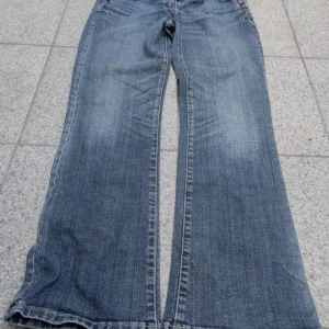 Blå bootcut jeans med strassdetalj - Snygga blå bootcut jeans med låg midja! Toppenskick!💓💓 midjemått: 40cm innerbenslängd:72cm❤️