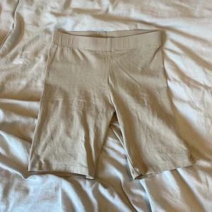 Beige cykelshorts från Gina Tricot - Snygga beige cykelshorts från Gina Tricot, basically basics-kollektionen. De är midwaist och har en enkel, stilren design utan synliga detaljer. Perfekta till sommaren och superbekväma tack vare mjukt bomullsmaterial.