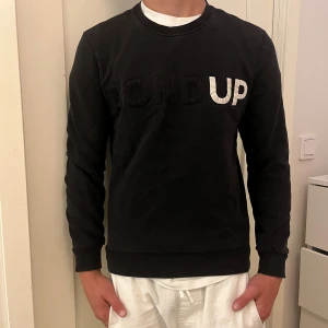 Svart sweatshirt från Dondup - Svart sweatshirt från Dondup med broderad logga i svart och vitt framtill. Klassisk rund halsringning och långa ärmar. Tröjan är i mjuk bomull och har ribbade muddar vid ärmslut och nederkant. Nypris runt 800