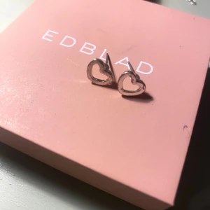 Silverfärgade hjärtörhängen  - Snygga örhängen i silverfärgad metall, formade som öppna hjärtan. Perfekta för att ge din look en gullig och stilren touch.