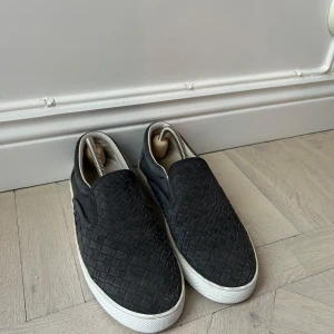 Bottega Venetta Slip-ons - Säljer ett par mörkblåa Bottega Venetta slip-on sneakers med vit sula och flätad ovandel i bra skick. Skorna har en stilren design utan snörning och passar perfekt till en avslappnad look. Köpta här på Plick för 2900kr. ( kvitto och låda ingår ej ) mvh Vilmer