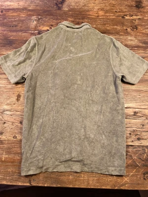 Grå frottéskjorta från Jack and East west - Snygg grå skjorta från East west mjuk frotté. Skjortan har korta ärmar, klassisk krage och knäppning med ljusa knappar framtill. Perfekt för dig som gillar chill och avslappnad stil. Materialet är riktigt skönt mot huden och ger en cool vibe.