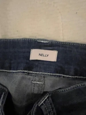 Blå bootcut jeans från Nelly, stl 34 - Snygga blå bootcut jeans från Nelly i storlek 34. Perfekt för dig som gillar retrovibbar och breda ben. Har sytt ner dom till min längd ca 160 är jag och det kostade o sy ner dom drf dyrare o it använt mycket 