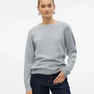 Grå stickad tröja från Vero Moda - Mysig grå stickad tröja från Vero Moda med rund halsringning och ribbade muddar. Tröjan har en klassisk passform och enkel design som funkar året runt.