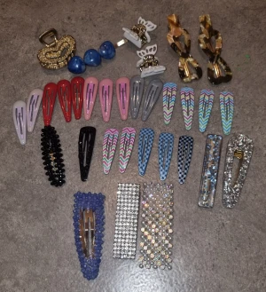 Stort paket hårspännen och klämmor - Säljer ett stort paket med hårspännen och hårklämmor i olika färger och former. Inkluderar glittriga, pärlbeströdda och mönstrade spännen i blått, svart, silver, guld, rosa, rött och grått. Perfekt för att variera din frisyr med både klassiska och trendiga detaljer.
