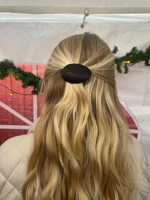 Svart satin hårklämma - Snygg svart hårklämma med oval form, perfekt för att ge frisyren en clean och stilren touch. Klämman är klädd i mjuk satin som ger en lyxig känsla och som minskar slitage på håret.  Spännet på baksidan är även det klätt i satin vilket bidrar till ett bra grepp och är skonsammare mot håret. 