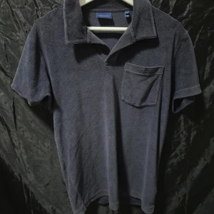 Mörkblå frotté t-shirt från GANT - Mörkblå t-shirt från GANT i mjuk frotté med klassisk krage och bröstficka. Kortärmad modell med relaxed vibe, perfekt för chill dagar. Snygg och enkel att matcha med jeans eller shorts. Den är väldigt snygg och knappt använd. Säljer den på grund av liten användning. Storlek M skick 9,5/10.