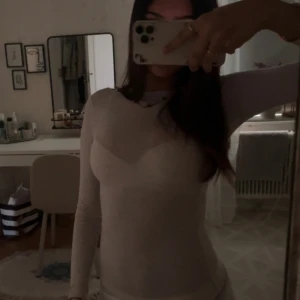 Ljusbeige långärmad Intimissimi - En enkel och stilren ljusbeige Intimissimi topp med tight passform. Säljer denna då den inte kommer till någon användning längre, den är i bra skick men har en liten defekt vid halsringningen men det är inget man lägger märke till.