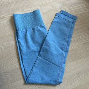 Blå seamless leggings - Snygga ljusblå leggings med bred ribbad hög midja. Aldrig använda.