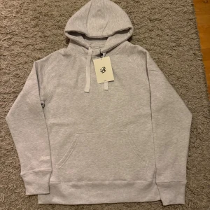 Hoodie - HELT NY!Snygg ljusgrå hoodie från Russemerch i storlek L. Klassisk modell med huva, snörning och känguruficka framtill. Mjuk och skön bomullsblandning, perfekt för chill dagar. Diskret broderad logga på ärmen och ribbade muddar vid ärmslut och nederkant.